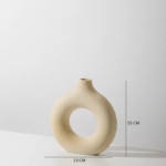 An off-white minimal ceramic vase in a donut shape