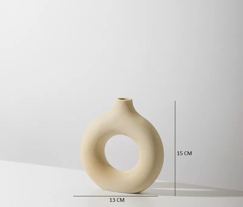 An off-white minimal ceramic vase in a donut shape